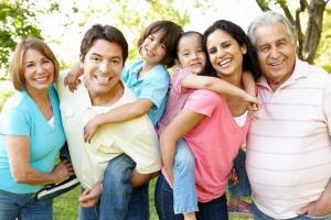 Hispanic Family In Park And Smiling At Camera