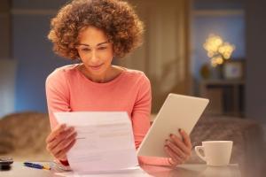 woman with tablet comparing a paper