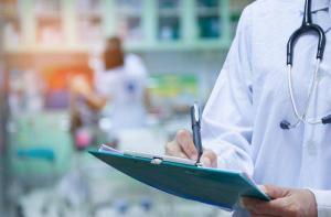 Doctor writing a medical prescription in hospital