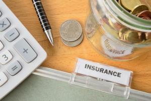 Insurance file with calculator, pen, coins and glass jar