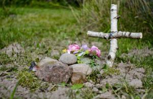 Grave covered by stones and with wooden cross