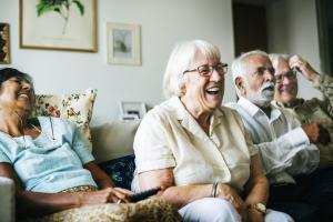 Senior people watching television together