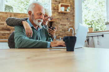 Senior couple reading on laptop