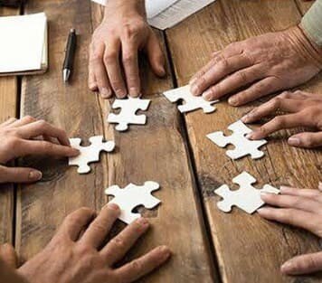 Different hands completing a puzzle