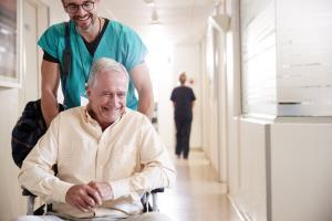 Male nurse pushing senior male in wheelchair